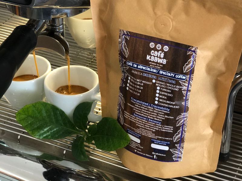 Espresso machine pouring coffee into 2 small coffee cups, besides a bag of Specialty Coffee Oaxaca Mixteca 